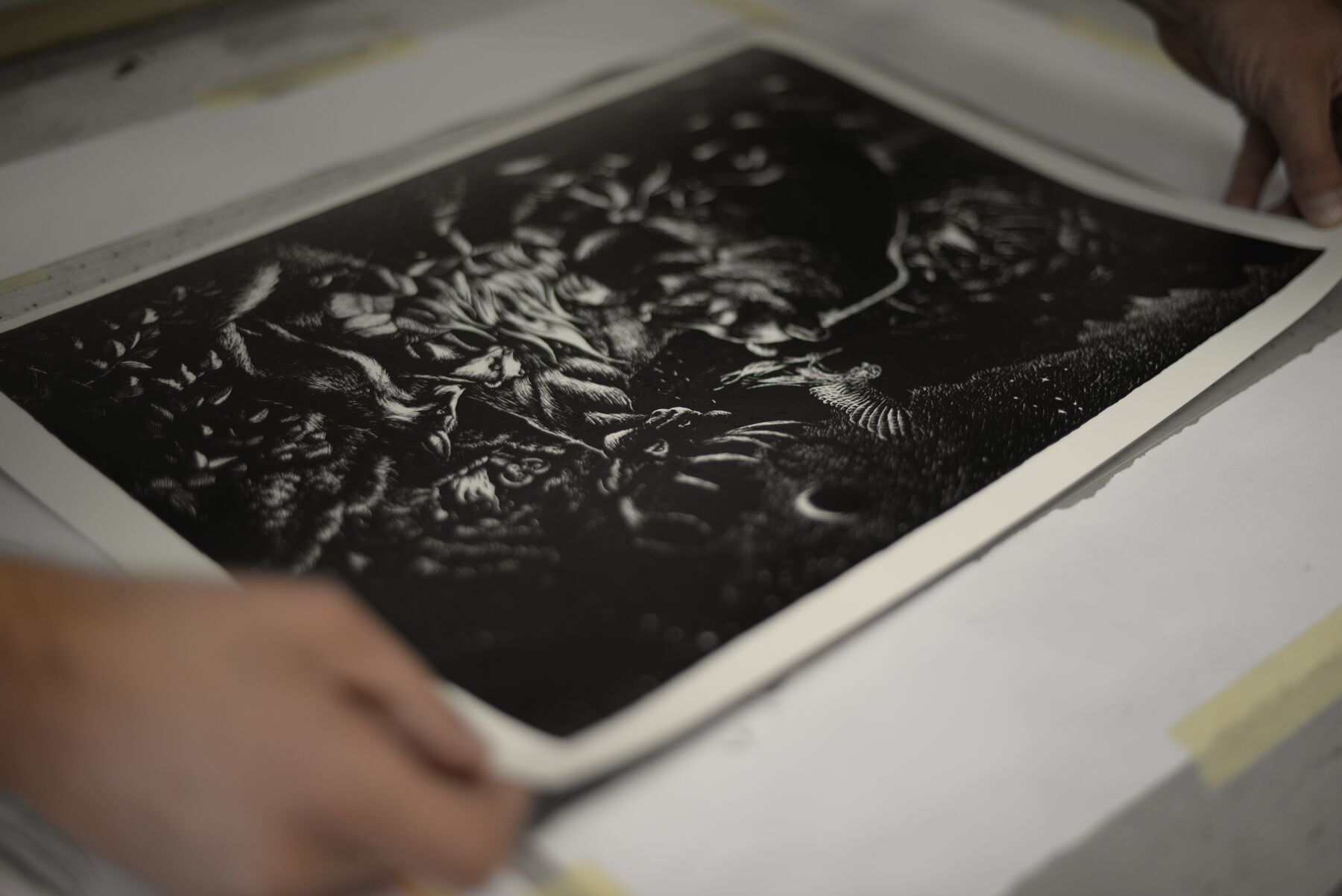 Hands carefully lifting a freshly printed Bonfire sheet from the printing bed