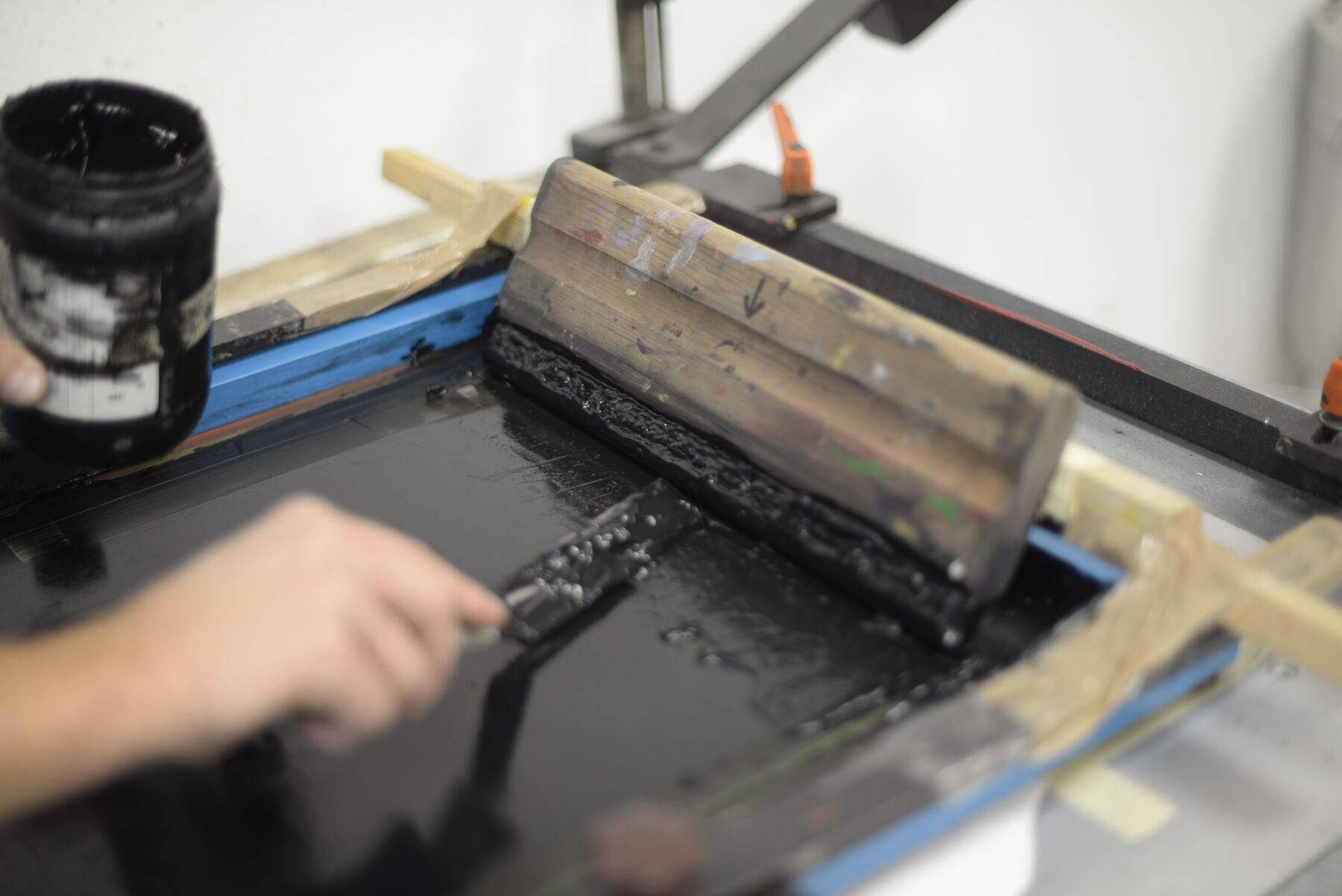A printer spreading ink across the screen by hand