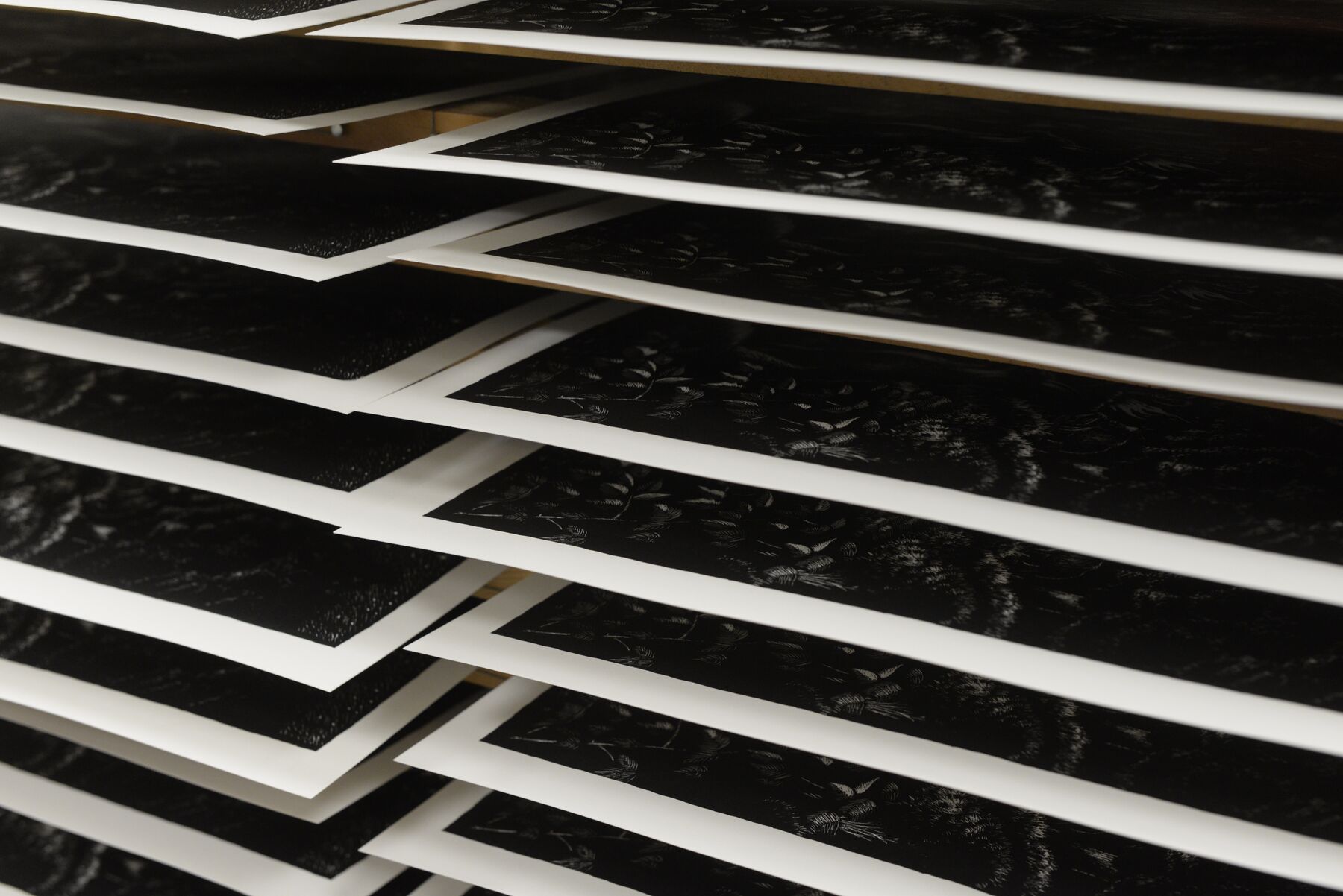 Freshly printed silkscreens drying in a rack at the BeeInk workshop