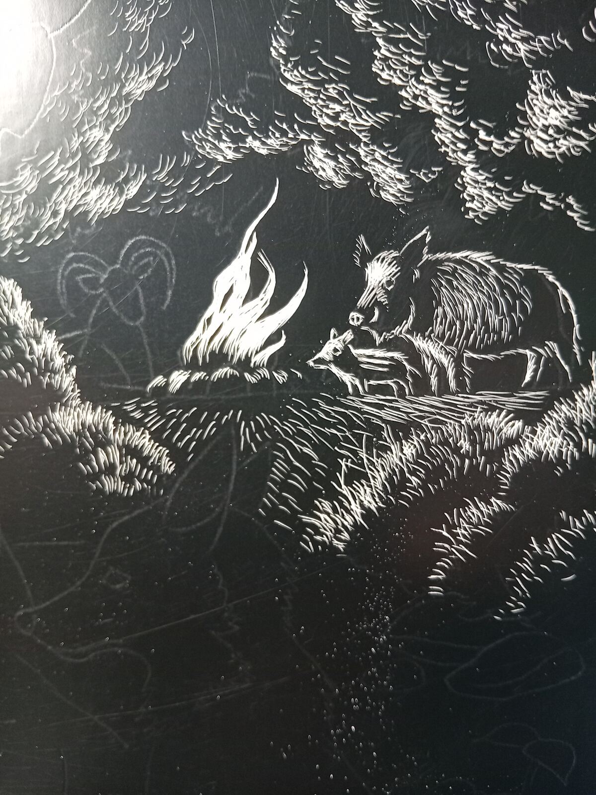 White linework detail of a ram and wild boar around a small fire among trees